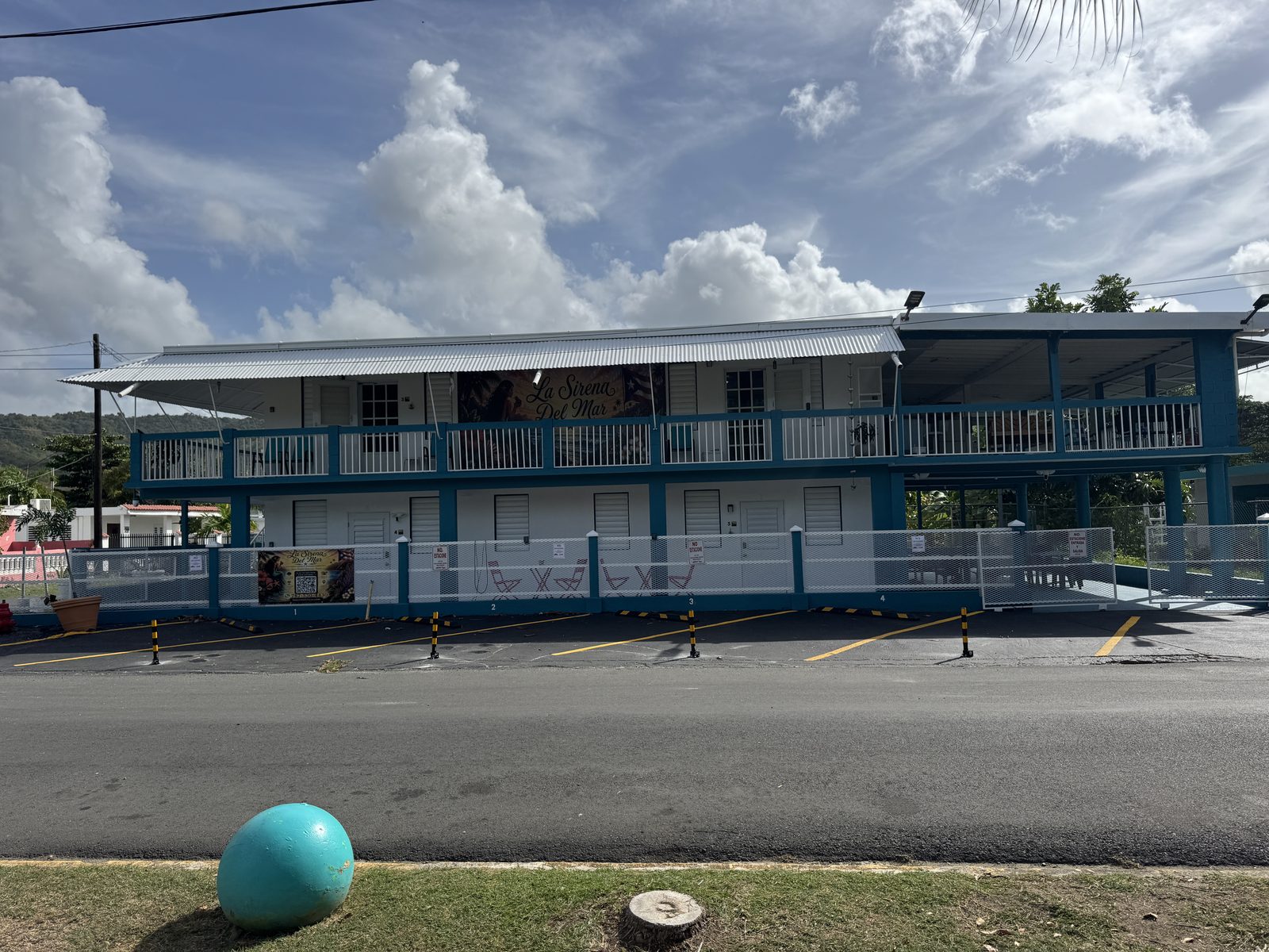 La Sirena del Mar — Caribbean blue two-story building with the La Sirena Del Mar sign, balconies and gated private parking