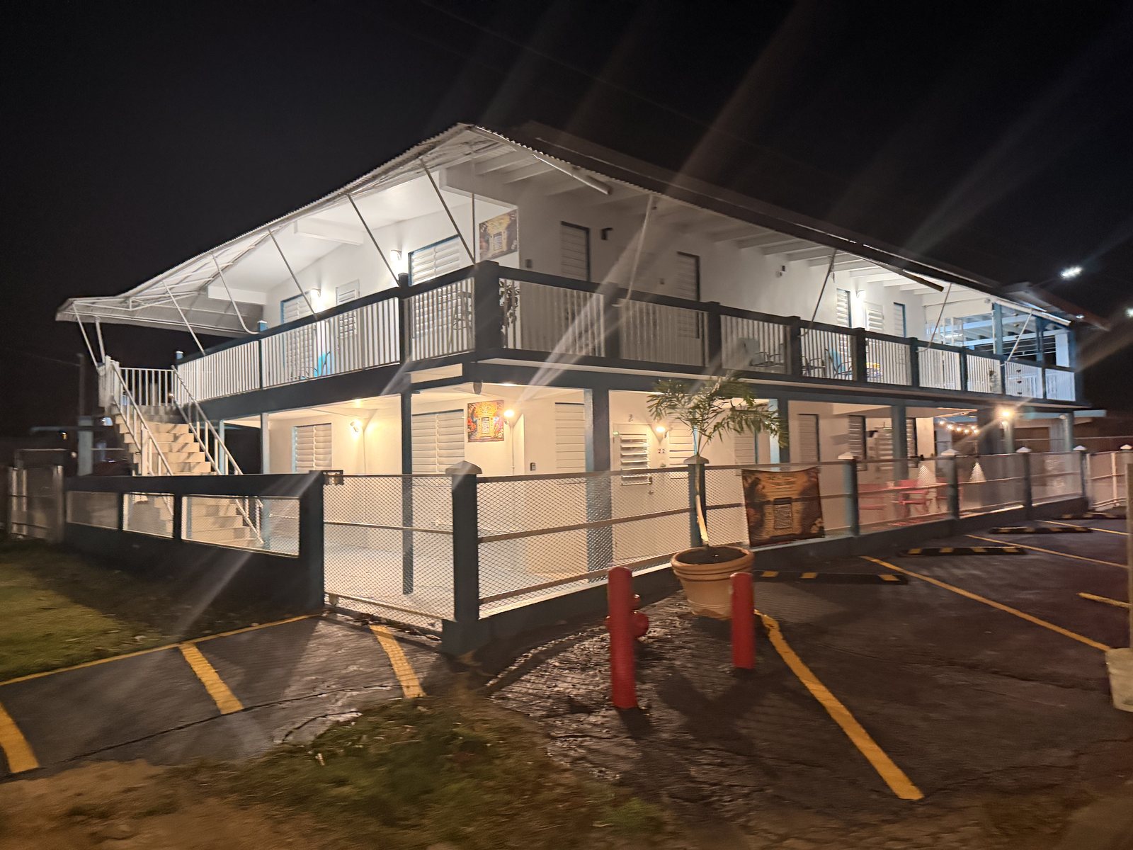La Sirena del Mar at night — the two-story building lit up, balconies and gated private parking